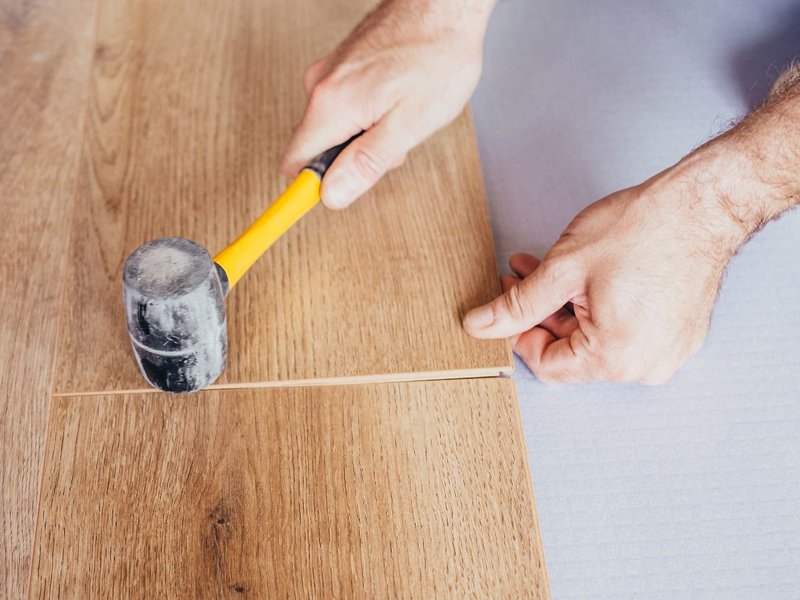Person installing hardwood flooring from Northcraft Flooring & Design in Lee's Summit, MO