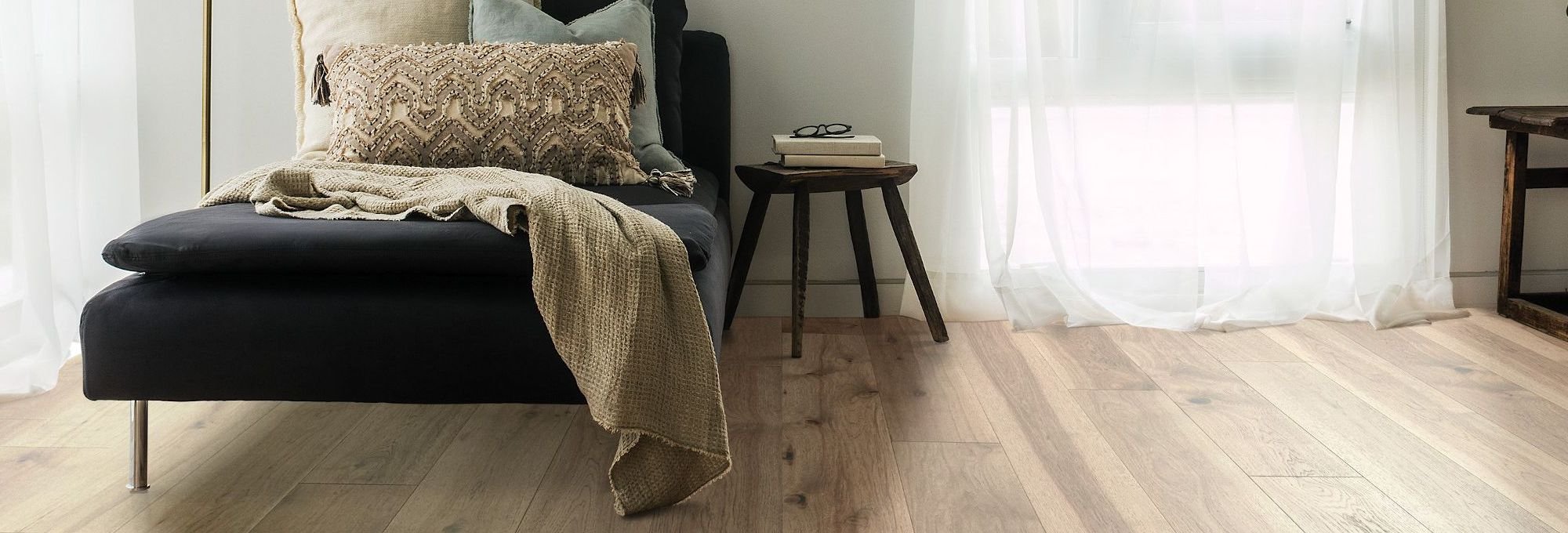 Bedroom with a black bed and hardwood flooring from Northcraft Flooring & Design in Raytown, MO