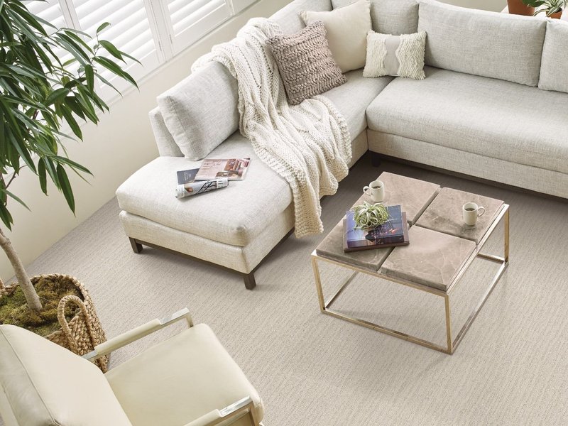 Living room white corner sofa, a table and a chair and carpet from Northcraft Flooring & Design in Lee's Summit, MO