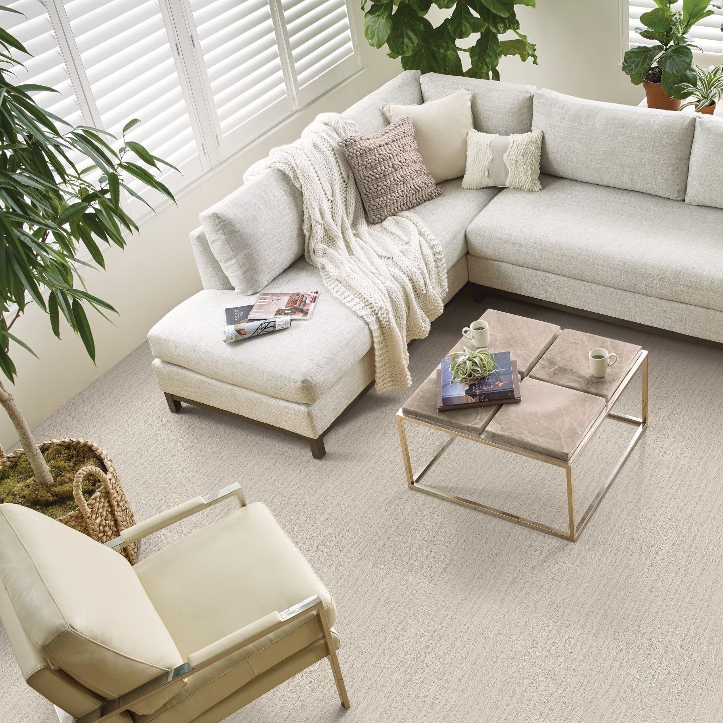 Living room white corner sofa, a table and a chair and carpet from Northcraft Flooring & Design in Raytown, MO